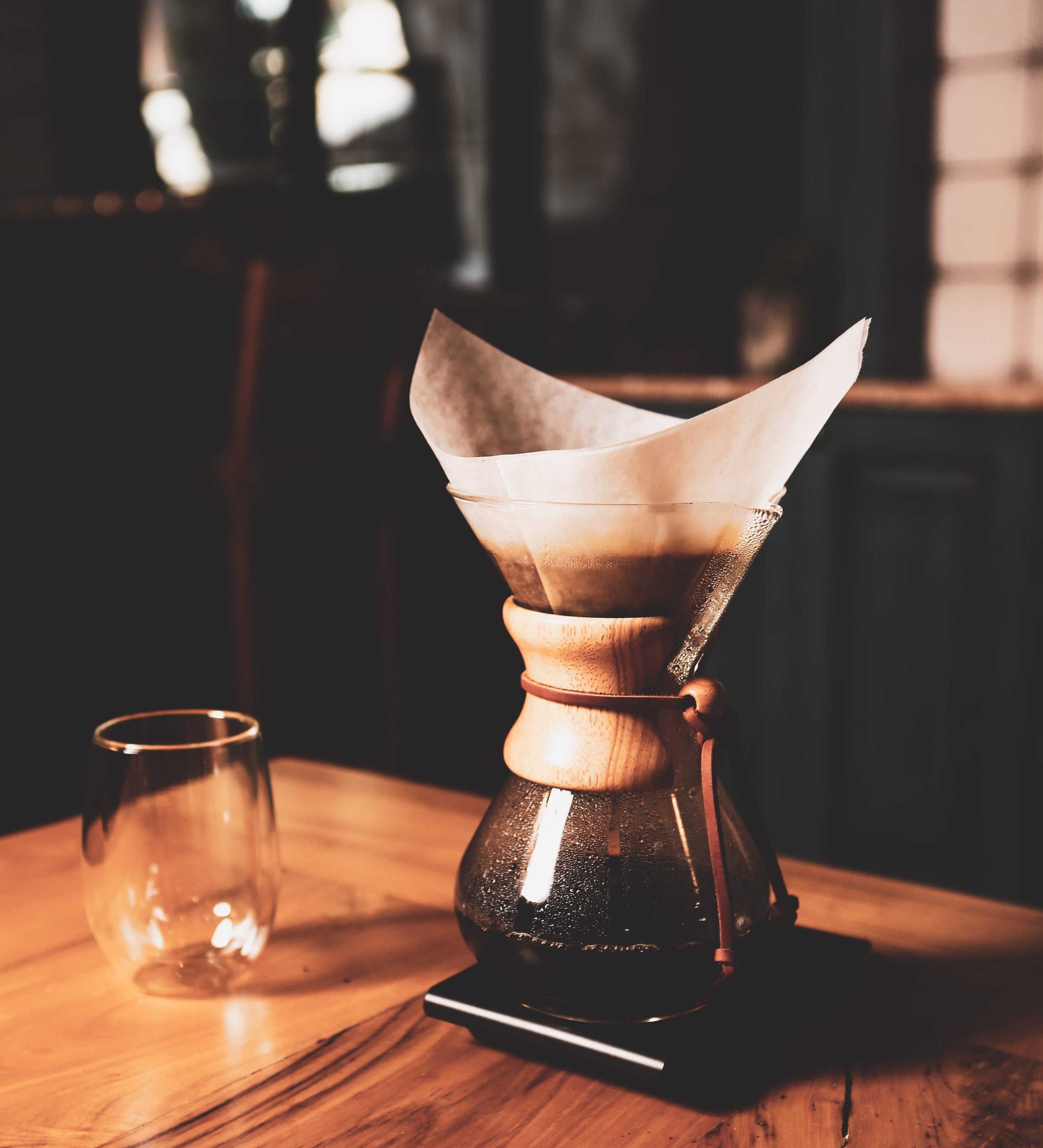 Coffee brewing apparatus on a wooden table with a blurred background